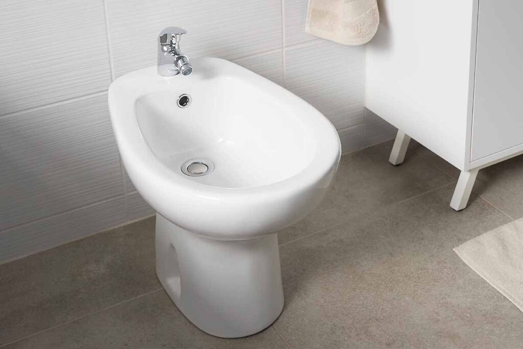 Un bidet moderne installé dans une salle de bain élégante, parfait pour une bonne hygiène intime.