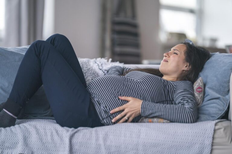 Femme enceinte tenant son ventre en raison de douleurs ligamentaires