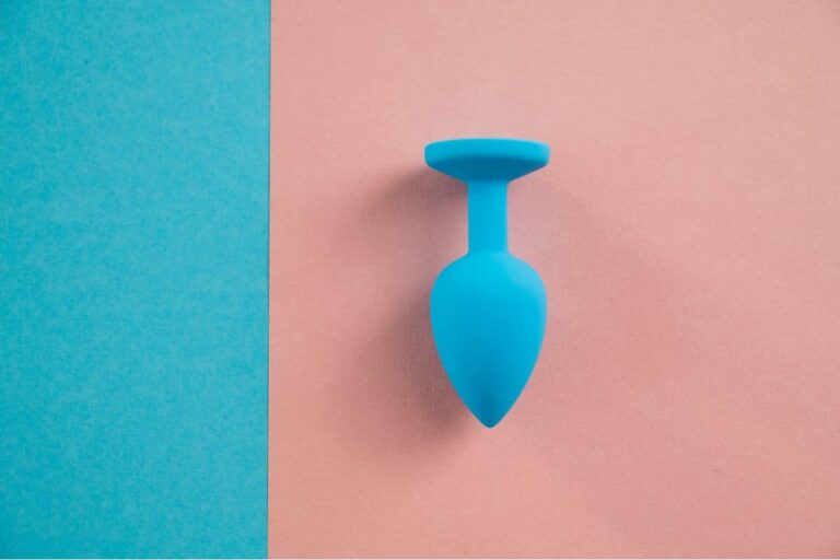 Un plug anal en silicone noir posé sur une surface réfléchissante