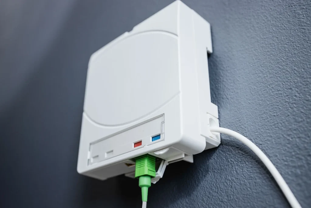 Gros plan sur une prise terminale optique (PTO) en cours de raccordement pour une installation fibre optique.